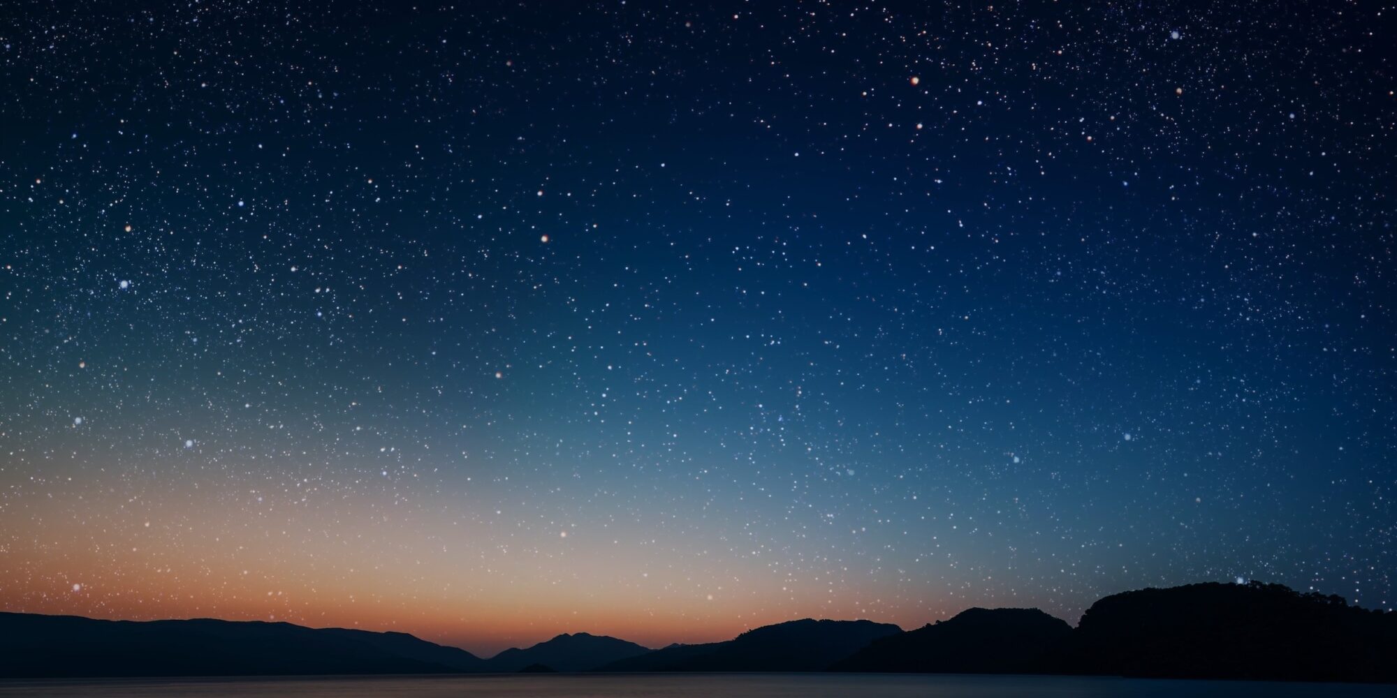 movement of stars in the night sky with the view of mountains